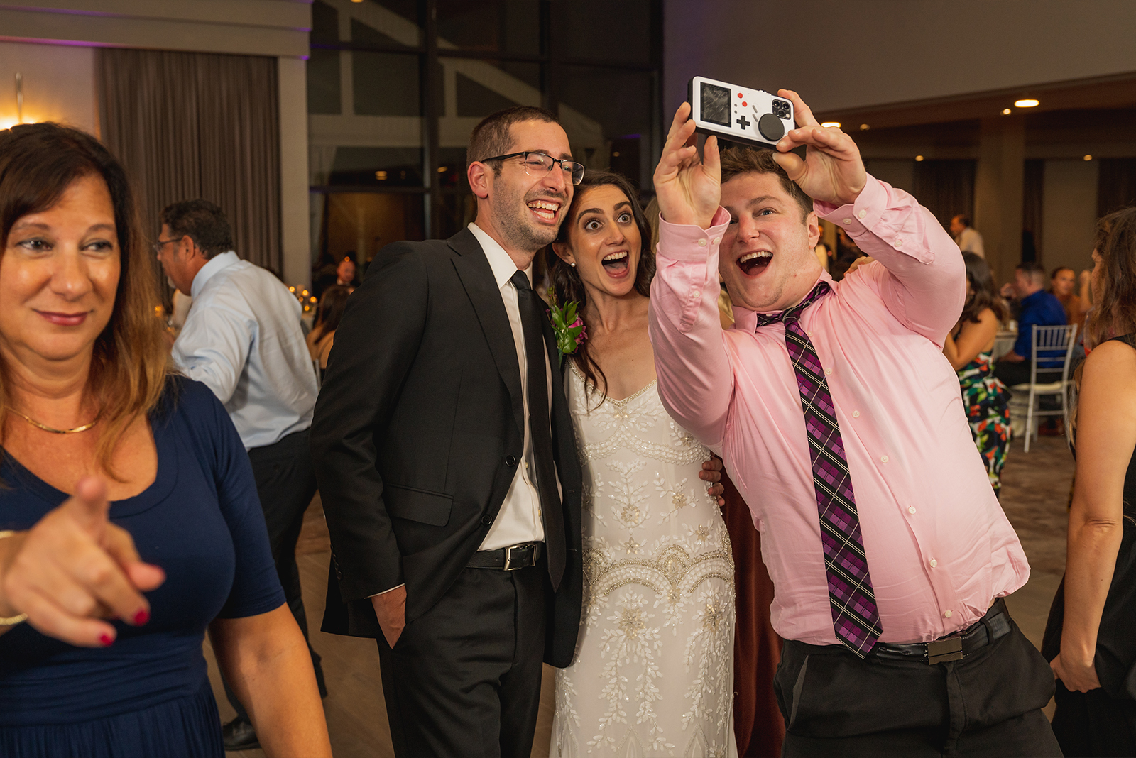Bride and groom with friend taking selfie, smiling, fun, classy wedding reception at Landerhaven, Mayfield Heights OH