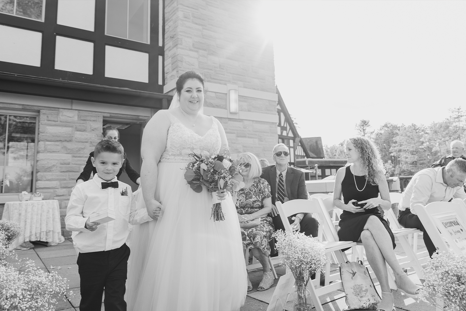 Bride with son, ring bearer, bridal march, bridal processional, cute, smile, black and white, classic wedding photo, outdoor September wedding ceremony at Punderson Manor Lodge & Conference Center, Newbury Township OH