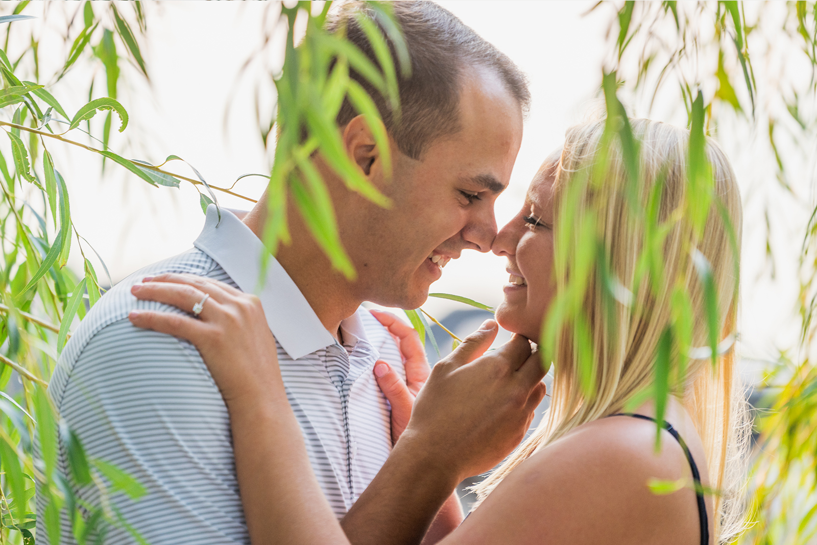 Man and woman fiancee engagement photo, couple portrait, cute couple pose, weeping willow tree, nature, green, water, Lake Erie, Edgewater Beach, Cleveland Metroparks