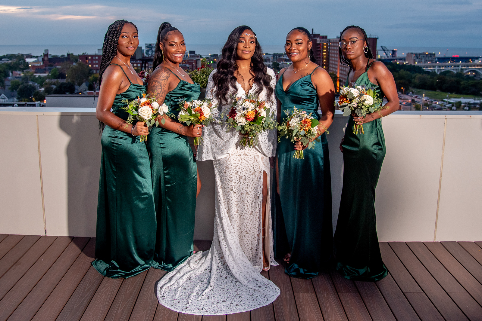 Bride with bridesmaids, bridal party portrait, African American bride, African American wedding, night photography, night wedding photo, downtown Cleveland skyline, Lake Erie, urban wedding ceremony at Penthouse Events, Ohio City, Cleveland Flats