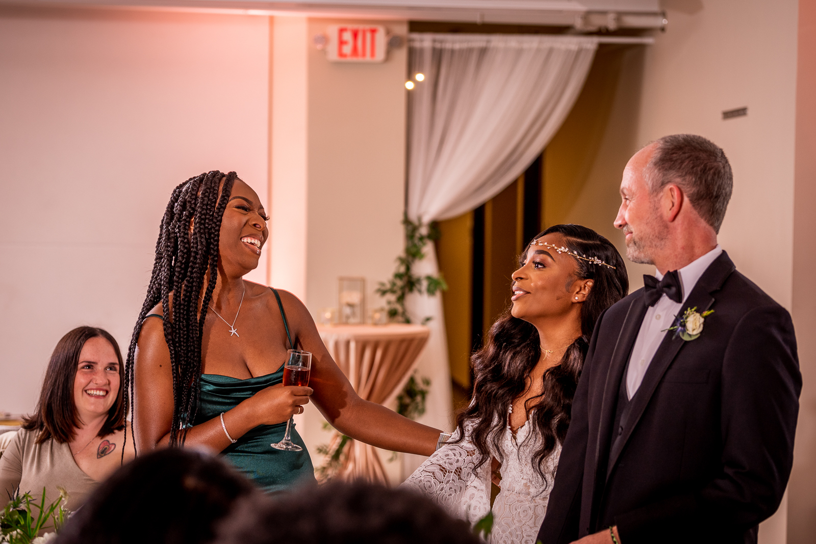 Bride and groom with bridesmaid, wedding speech, wedding toast, smile, laugh, candid wedding photo, African American wedding, pink light, pink uplighting, urban wedding reception at Penthouse Events, Ohio City, Cleveland Flats