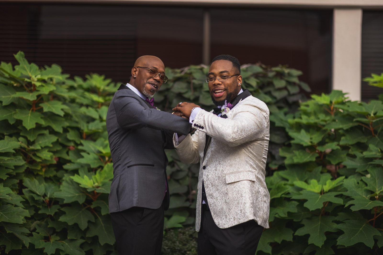 Groom and father, parent of the groom, bridal party portrait, fun bridal party portrait, green bushes, nature, African American groom, African American wedding, romantic wedding ceremony at Hilton Akron/Fairlawn