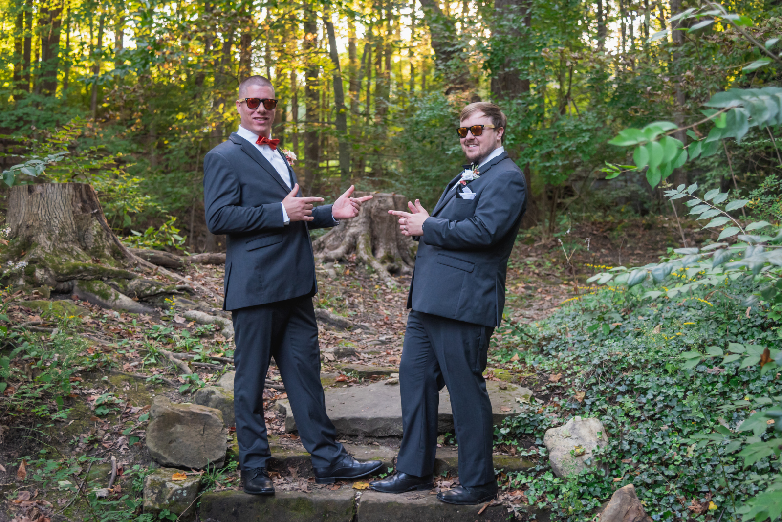 Groomsmen wearing sunglasses, bridal party portrait, unique bridal party portrait, fun bridal party portrait, finger guns, forest, nature, fall leaves, fall colors, trees, fall wedding, cute outdoor wedding ceremony at Grand Pacific Wedding Gardens