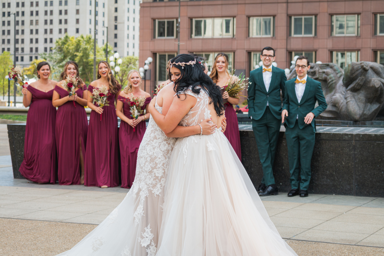 Two brides first look with bridal party, bridal party portrait, large bridal party, mixed bridal party, hug, sweet, romantic, urban, two wedding dresses, love is love, beautiful lesbian wedding at the House of Blues Cleveland, downtown Cleveland, Fountain of Eternal Youth