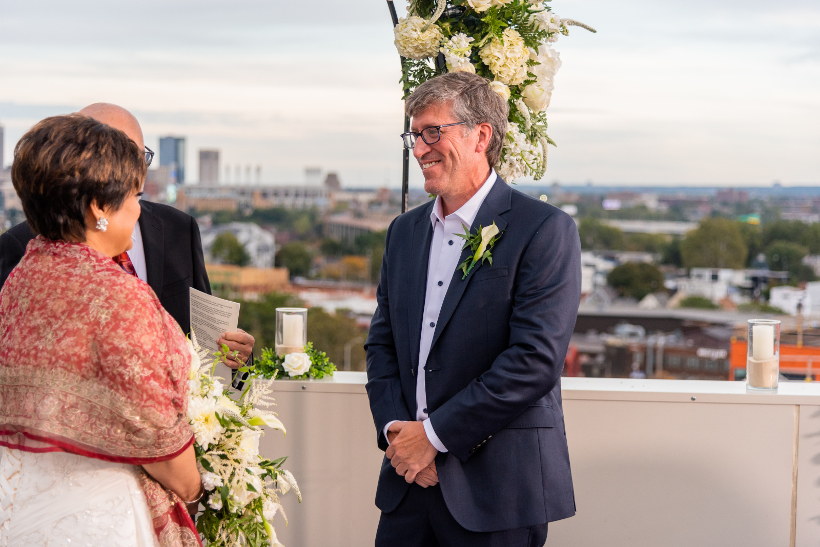 Bride and groom wedding ceremony, smile, cute, sweet, older groom, older couple, romantic outdoor urban wedding ceremony at Penthouse Events, Ohio City, Cleveland Flats, downtown Cleveland skyline, Lake Erie