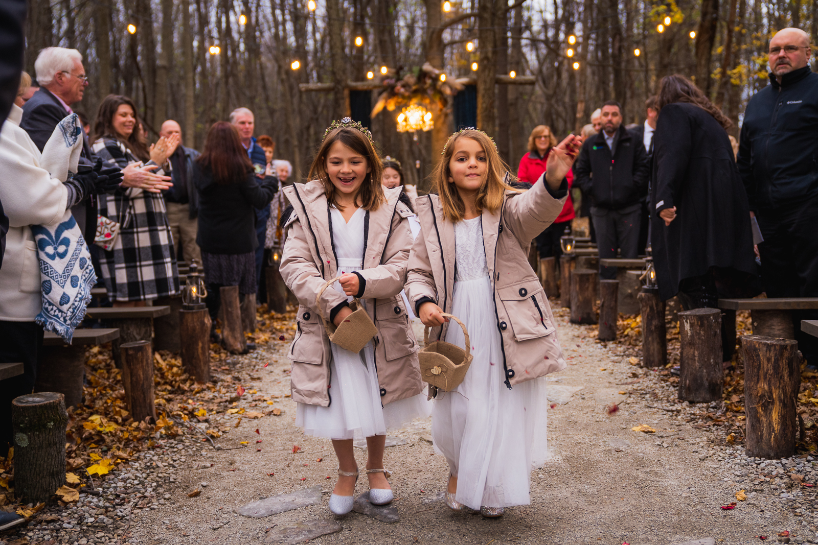 Flower girls toss rose petals at outdoor wedding ceremony at Gather at the Lakes