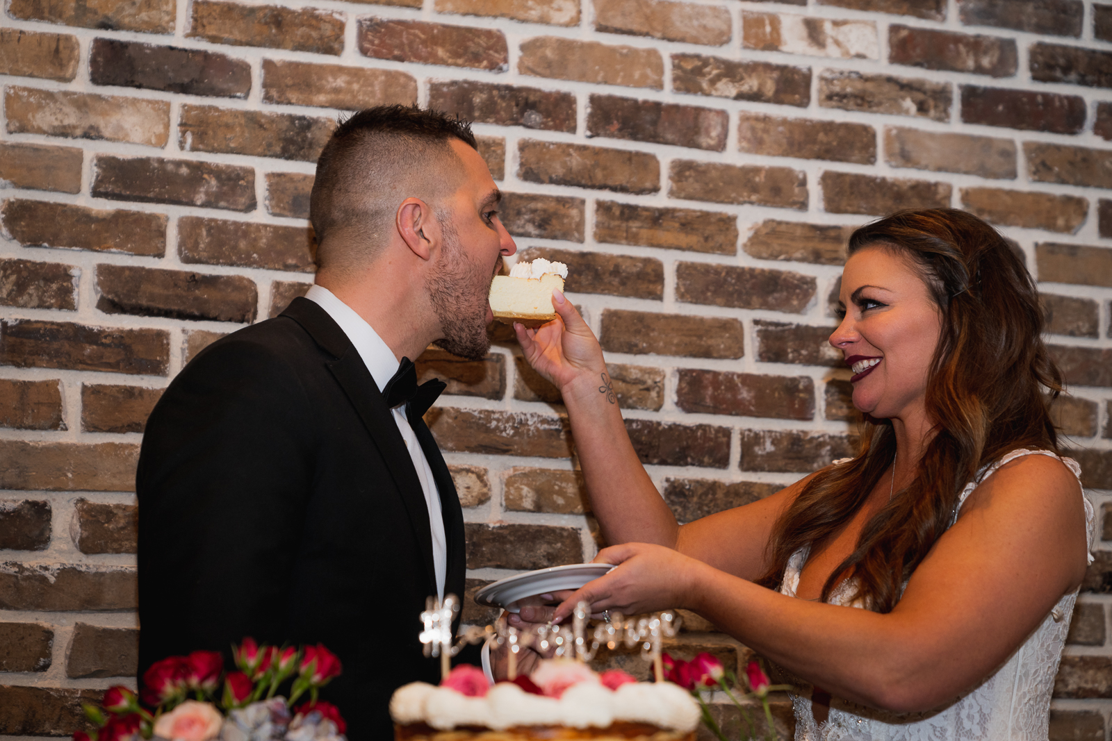 Bride and groom eat cake, cutting the cake, wedding reception at Gather at the Lakes