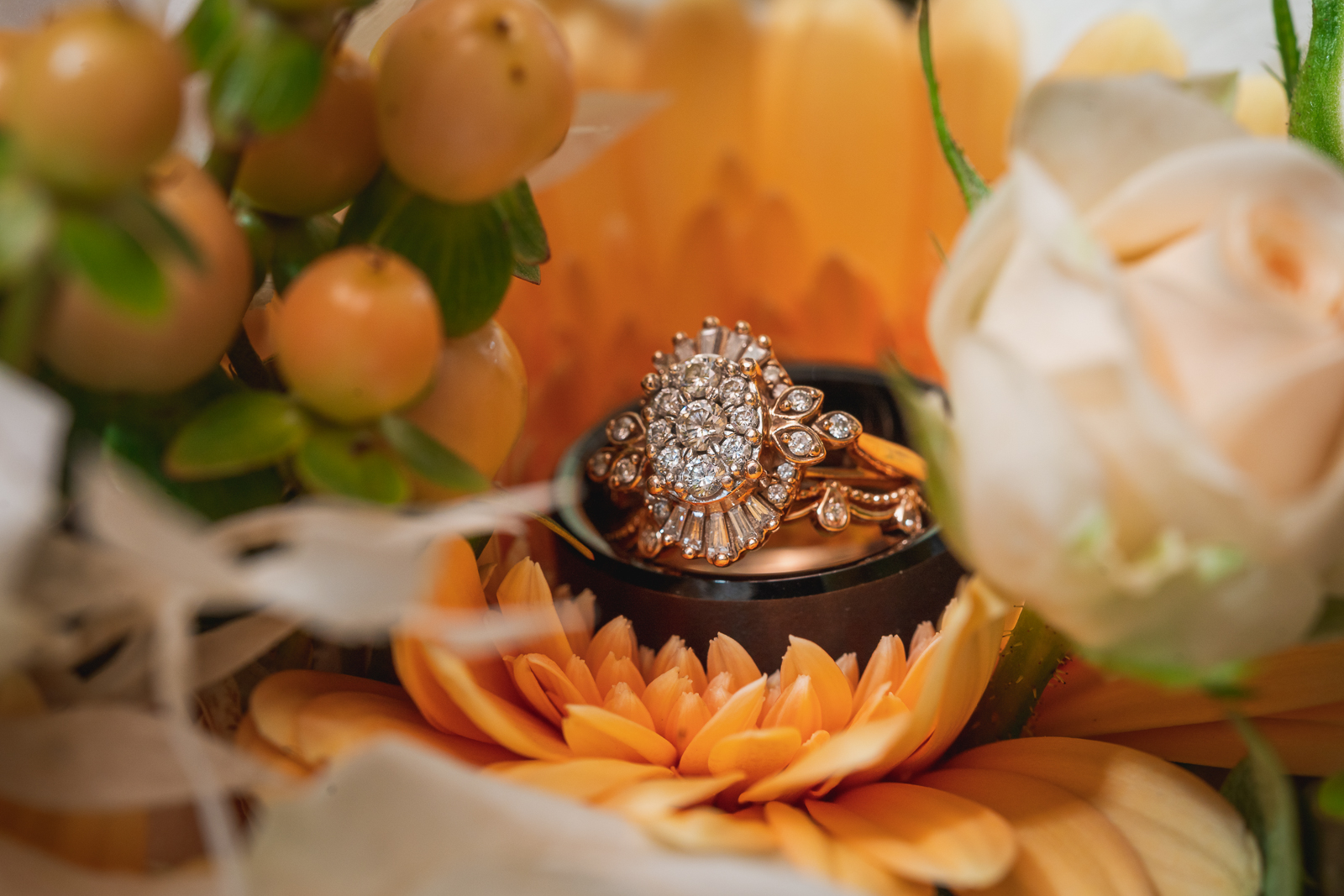 Wedding rings, engagement ring, wedding bands, diamond, beautiful engagement ring, flowers, orange, fall wedding, fall colors, rustic outdoor wedding ceremony at White Birch Barn