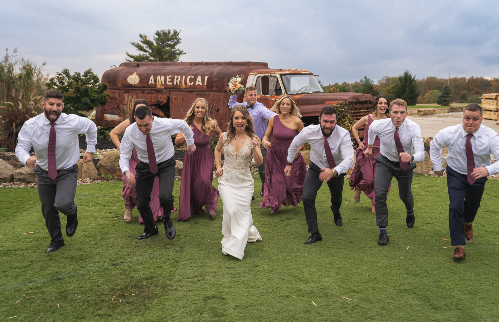Bride and groom with bridal party, bridal party portrait, fun bridal party portrait, unique bridal party portrait, old truck, American oil, fall wedding, rustic outdoor wedding ceremony at White Birch Barn