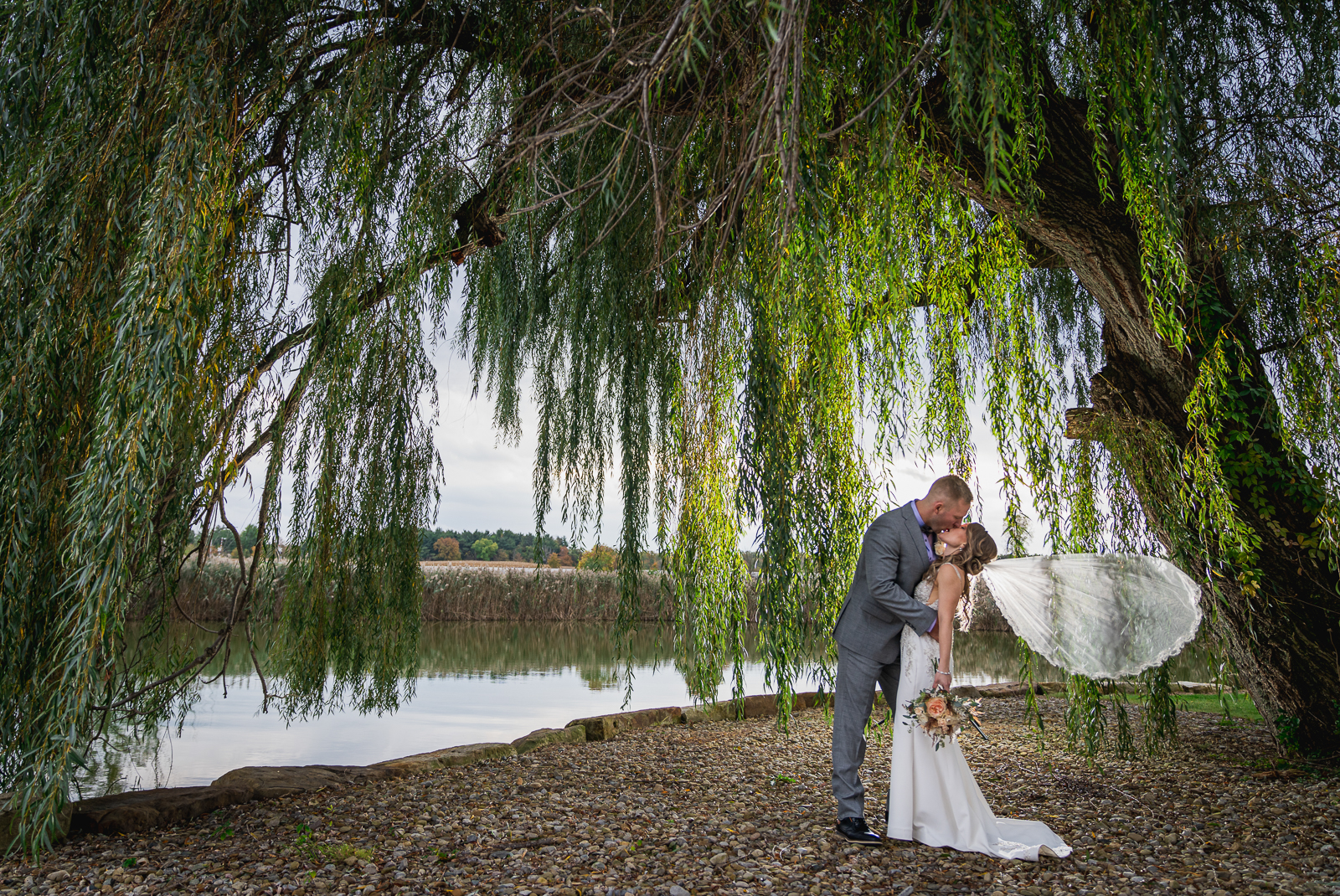 Bride and groom wedding portrait, kiss, veil, weeping willow, tree, nature, fall wedding, rustic outdoor wedding ceremony at White Birch Barn